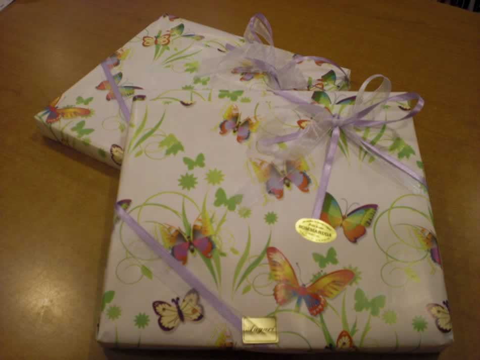 Pacchetto regalo con carta a farfalle e nastro lilla